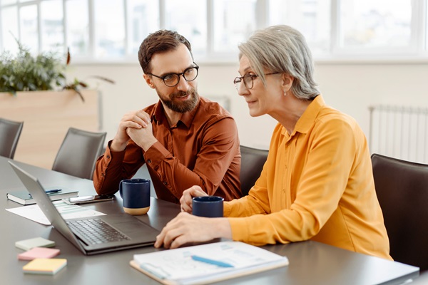 Two adults working together with a laptop