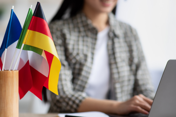 Colourful flags and a young woman using laptop at the background