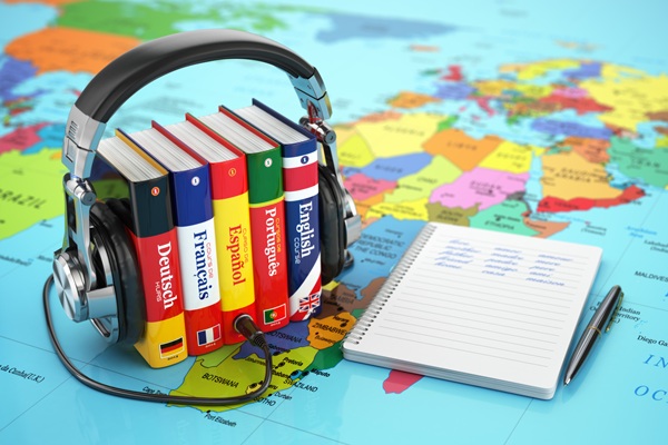 Image of multilingual dictionaries, a world map, and a notebook