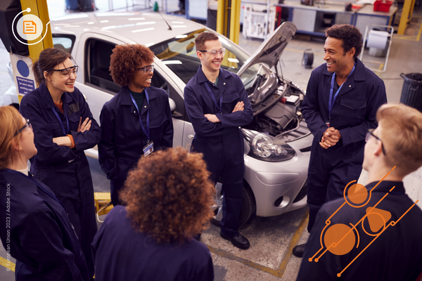 male mechanic teacher and a group of students smiling