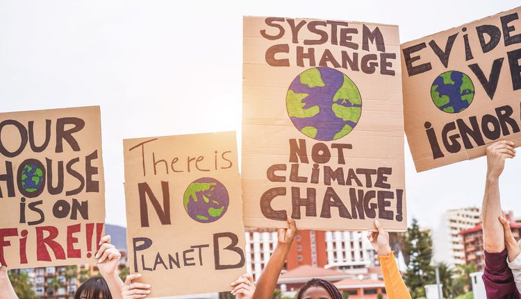 hands holding signs about climate change on a demonstration