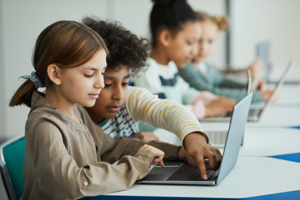 children in class using computers