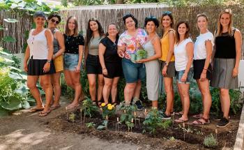 Photo of a group of happy teachers standing next to the vegetable garden they created with us in one of our Pedagogical Vegetable Gardens trainings.