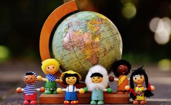 Multicultural figurines in front of a globe
