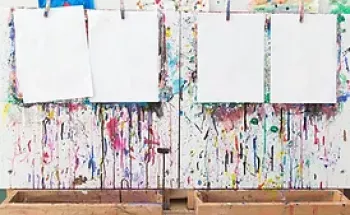 White papers hanging on a rope in front of a colorful wall 
