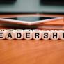 Tablet on the table with leadership spelled on cubes 