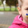 Child with heart in Ukranian flag colours painted on cheek 