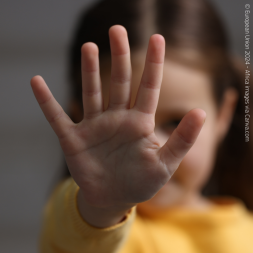 young girl with hand raised to sign stop